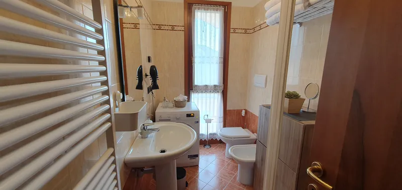 Bathroom with washbasin, washing machine and window