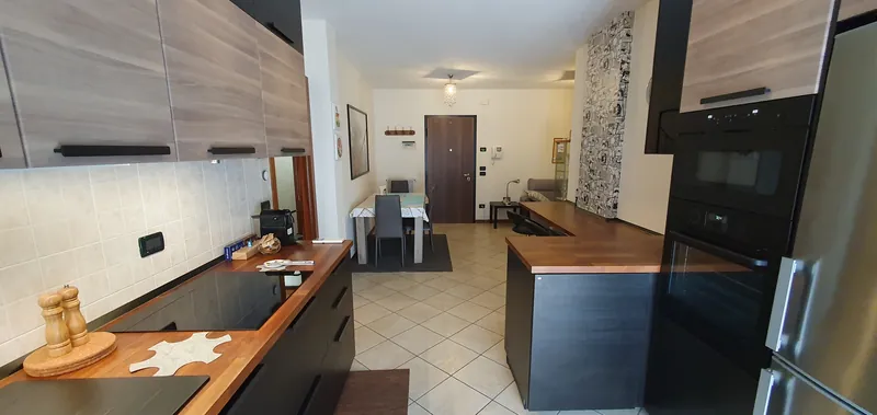 Kitchen with wooden worktop, looking towards the dining area and the entrance