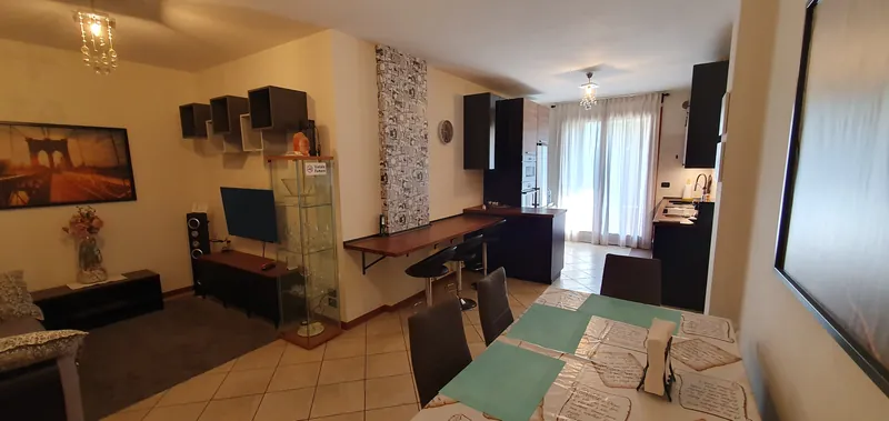 Living room open to the kitchen, with dining table and breakfast bar
